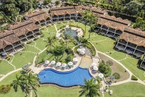 A resort with multiple bungalow-style buildings, a central swimming pool, and well-maintained gardens. - Spacious condo in enchanting Playa Flamingo - the most glorious views & 2 pools! (Playa Flamingo)
