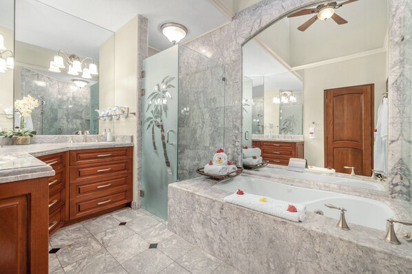 A bathroom with a large mirror, marble countertops, a bathtub, and wooden cabinetry. - Spacious condo in enchanting Playa Flamingo - the most glorious views & 2 pools! (Playa Flamingo)