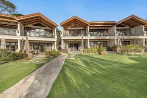 A two-story building with a covered patio area and a well-maintained lawn. - Spacious condo in enchanting Playa Flamingo - the most glorious views & 2 pools! (Playa Flamingo)