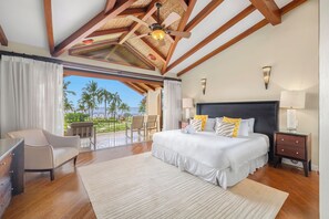 A bedroom with a large bed, a desk, a chair, and a balcony with a view of palm trees and the ocean. - Spacious condo in enchanting Playa Flamingo - the most glorious views & 2 pools! (Playa Flamingo)