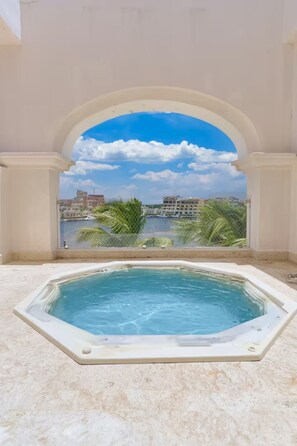 Ein Whirlpool in einem Zimmer mit Blick auf eine Skyline und Palmen.