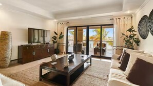 Un salon moderne avec un canapé, une table basse et un téléviseur.