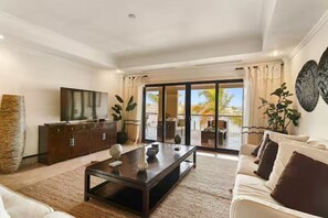 Ein modernes Wohnzimmer mit Sofa, Couchtisch und Fernseher.