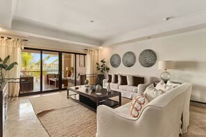 A modern living room with a sofa, coffee table, and decorative plates on the wall. - Luxury Penthouse in Cap Cana Marina with Jacuzzi (Punta Cana)