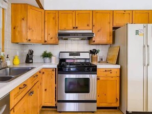 A kitchen with wooden cabinets, a stainless steel stove, a refrigerator, and a sink. - Serene + Spacious Boulder Oasis | Sleeps 10 | 30+ (Boulder)