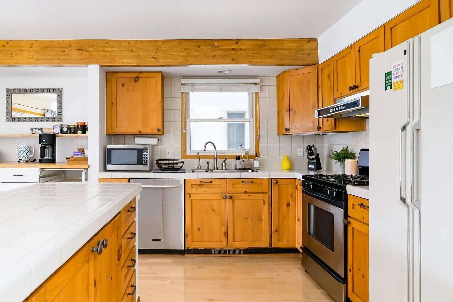 Una cocina moderna con armarios de madera, un microondas, un lavabo y una estufa.