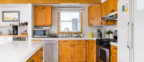 Una cocina moderna con armarios de madera, un microondas, un lavabo y una estufa.