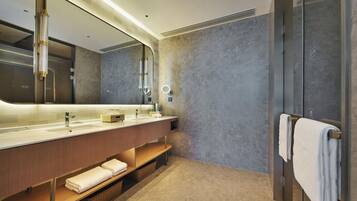 A modern bathroom with a large mirror, dual sinks, and a towel rack.