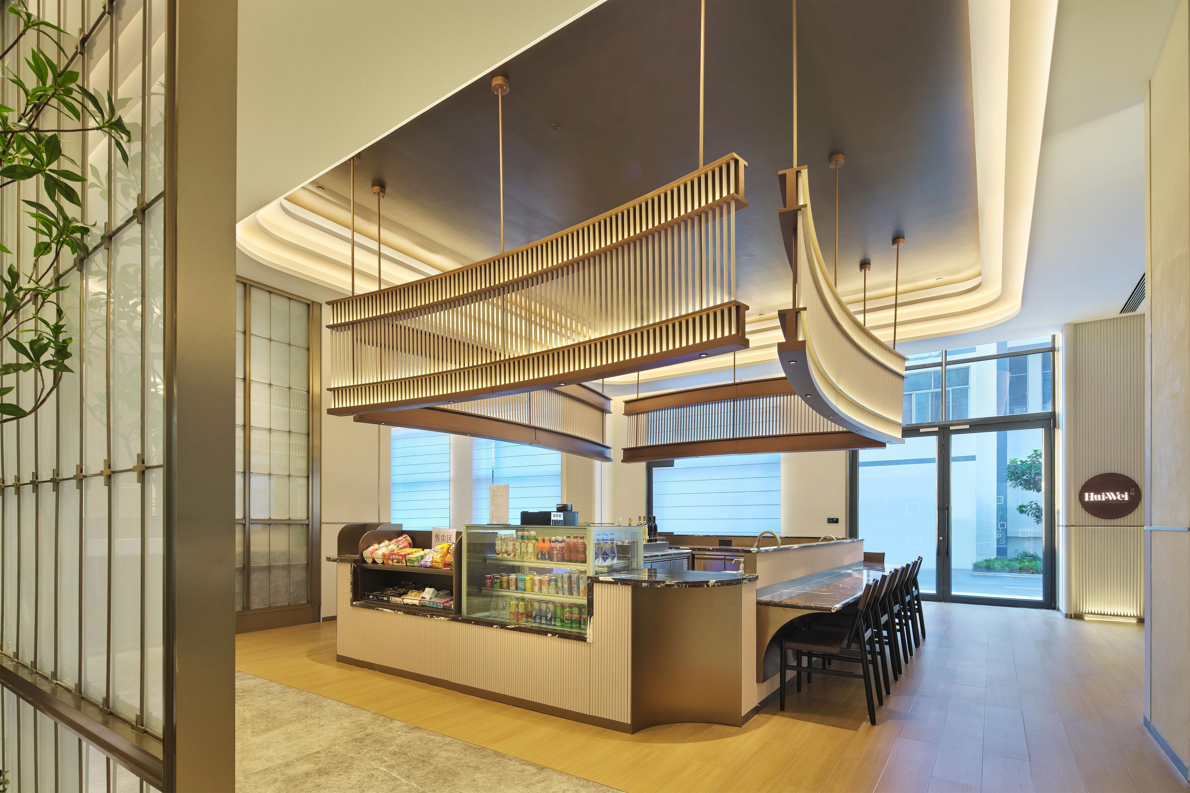 A modern interior with a reception desk, seating area, and a glass display case.