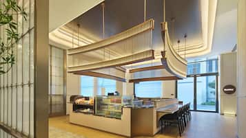 A modern interior with a reception desk, seating area, and a glass display case.
