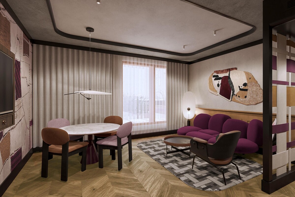A modern living room with a round table, purple sofa, and a large abstract wall art piece.