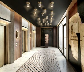 Un pasillo de hotel con piso estampado, paredes de madera y una escultura central.