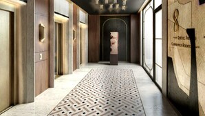 A hallway with a patterned floor, wooden panel walls, and a sculpture. - Canopy By Hilton Warsaw (Warsaw)