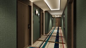 A hotel hallway with patterned carpet, wooden doors, and wall-mounted lighting. - Canopy By Hilton Warsaw (Warsaw)