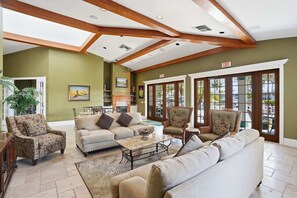 A spacious living area with a high ceiling, built-in bookshelves, and large windows. - 414 -Wheelchair Accessible - Sleeps 6 (Naples)