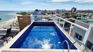 A rooftop pool with a view of the beach and cityscape. - COPIA0108 - Edifício Essencial Piata (Salvador)