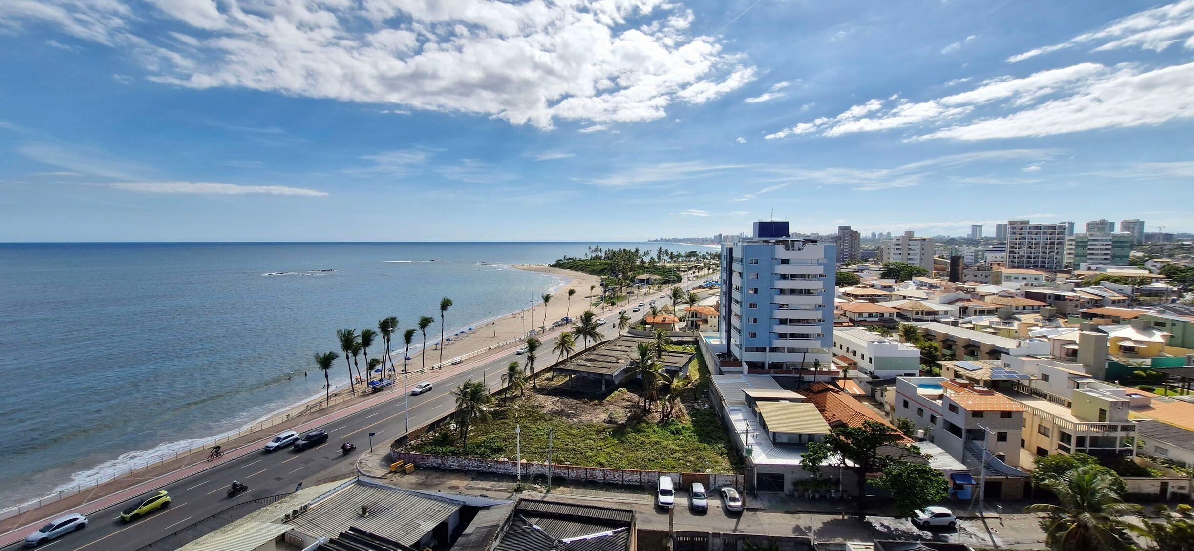 Un paisaje urbano costero con playa, carretera y edificios.