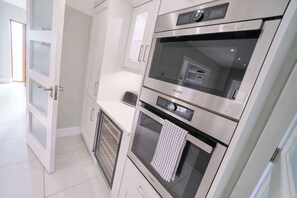 Eine moderne Küche mit Edelstahlgeräten, darunter eine Mikrowelle, ein Backofen und ein Toaster.