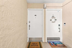 Two white doors with numbers 505 and 506, a lifebuoy decoration, and a doormat with a message.