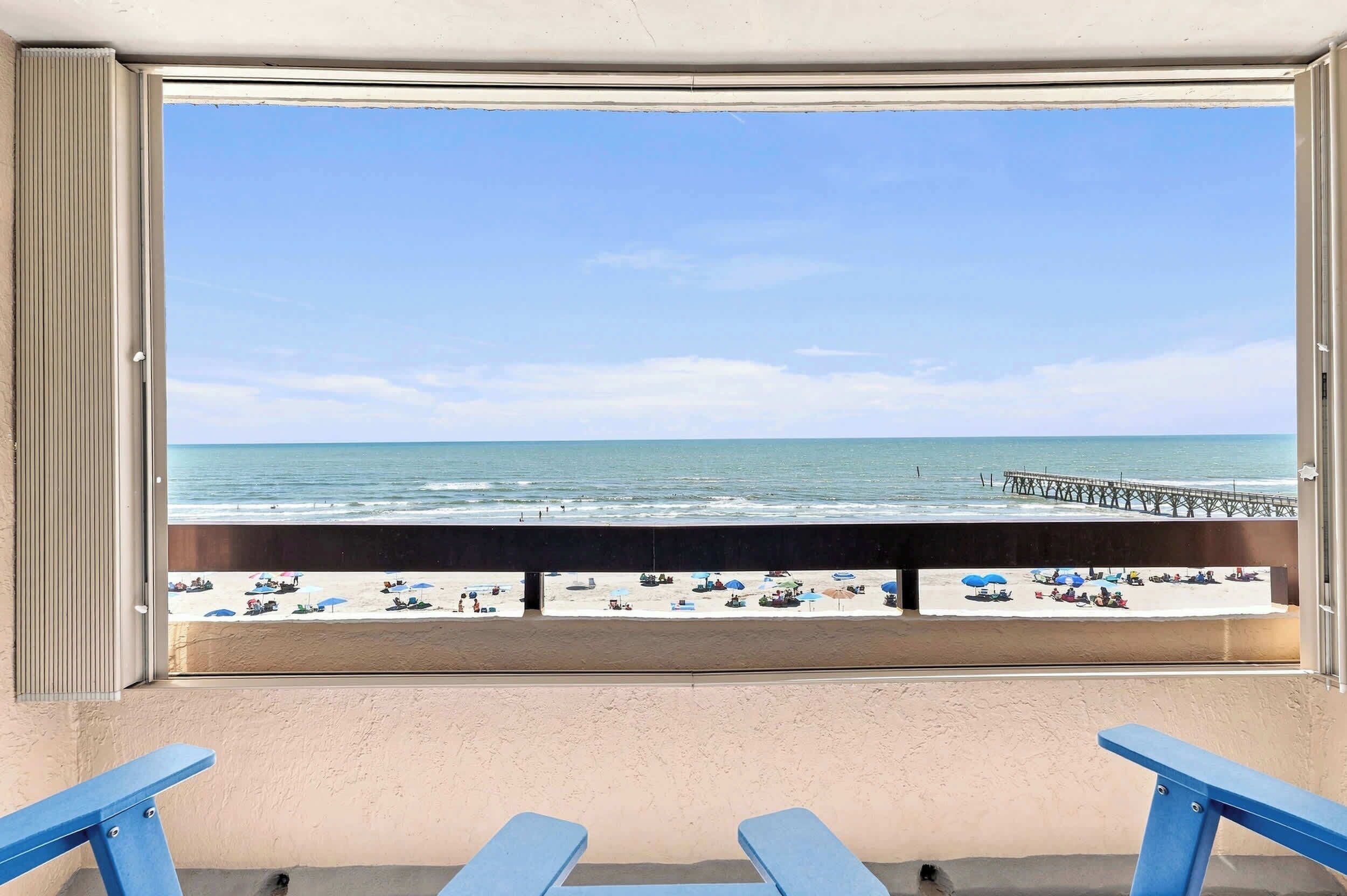 Un balcon avec vue sur une plage et une jetée.