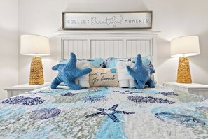 Een slaapkamer met een bed, twee nachtkastjes, een wandborden en een decoratief paneel.