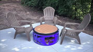 A round table with chairs in a shaded outdoor area.