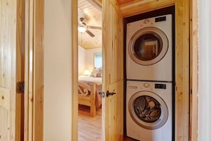 Ein Waschraum mit zwei Waschmaschinen mit Frontlader, Holzwänden und einem Deckenventilator.