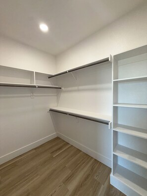 A room with white walls, a wooden floor, and built-in shelving units. - Arlington Park Estate - 3BR Luxury [Coming Soon!] (Dallas)