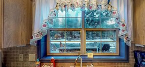 A window with a view of a snowy landscape, a wooden bench, and a kitchen sink. - Champoluc Mountain Retreat | River & Hot Tub (South Fork)