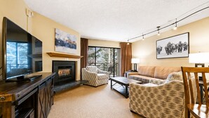 A living room with a fireplace, a television, and a sofa. - 1 BR+ sofabed & fireplace, walk to Village, Shuttle, Hot Tubs, 3/21-27/2027 ONLY (Vail)