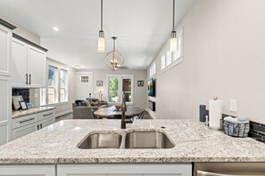 A modern kitchen with granite countertops, stainless steel appliances, and pendant lighting. - Southeast Boise Deluxe Home (Boise)