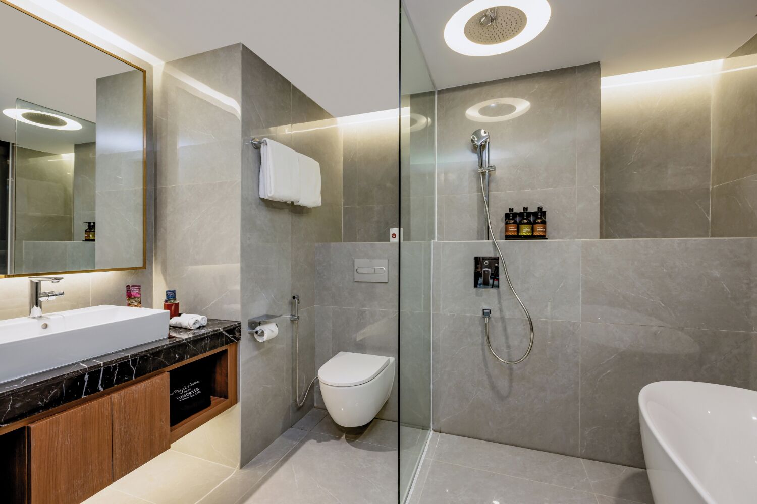A modern bathroom with a glass-enclosed shower, a white toilet, and a bathtub.