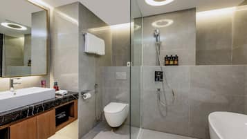 A modern bathroom with a glass-enclosed shower, a white toilet, and a bathtub.