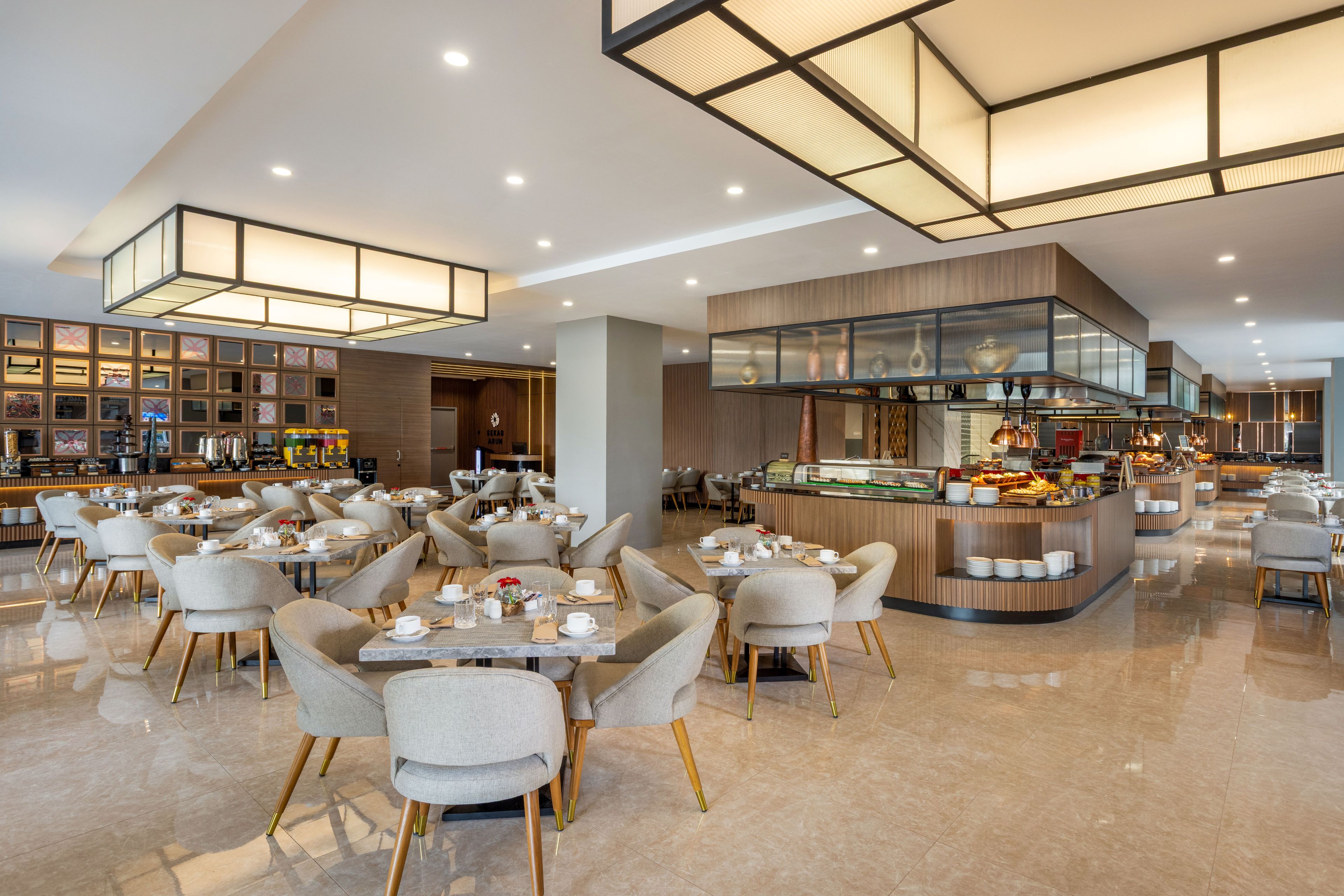 Un restaurant moderne doté de plusieurs espaces de restauration, d’un bar central et d’un buffet.