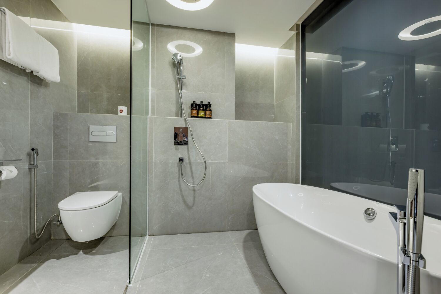 Un baño moderno con ducha envuelta en vidrio, inodoro y bañera independiente.