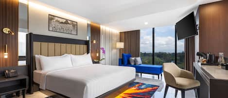 Una habitación de hotel moderna con una cama grande, un escritorio, una silla y un televisor.
