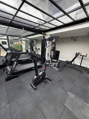 A gym with a treadmill, elliptical, and weight machines. - ADD HOTÉIS MORUMBI (São Paulo)