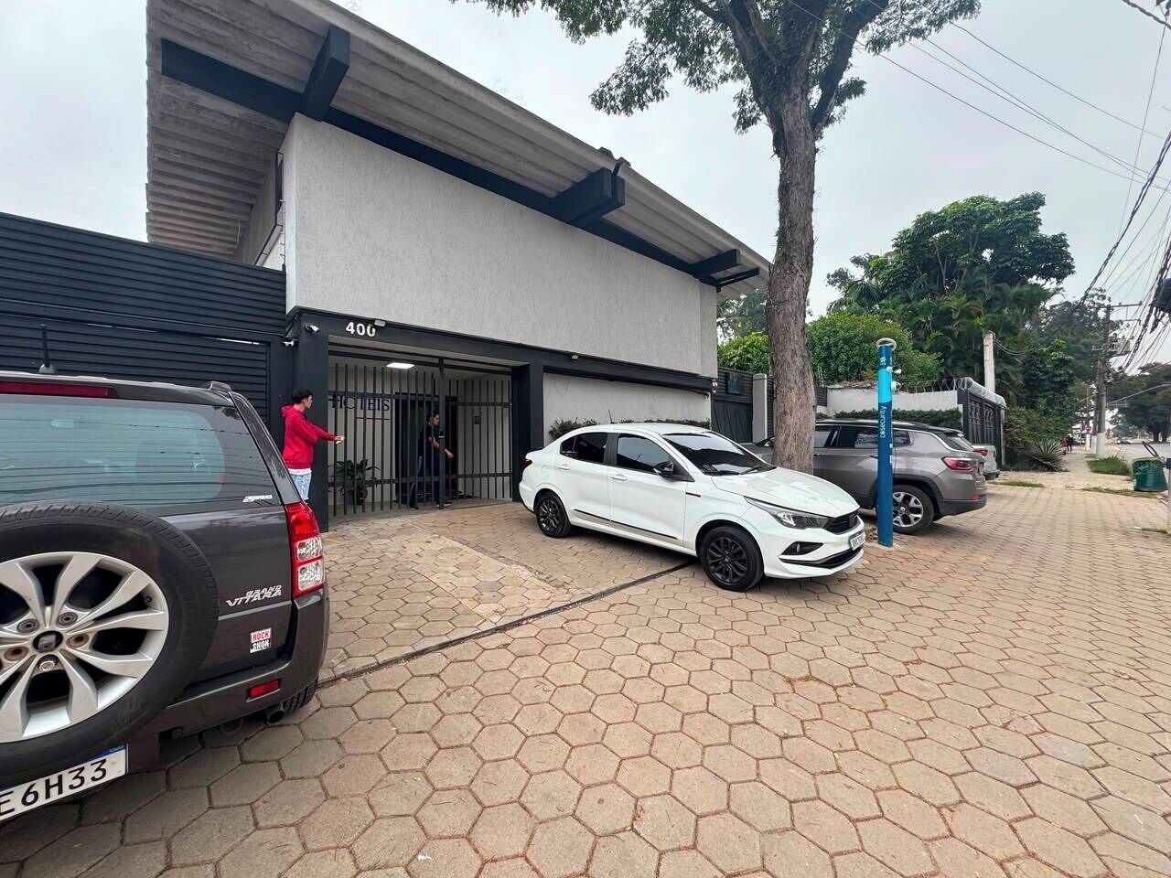 Un estacionamiento con un coche blanco y un SUV negro.