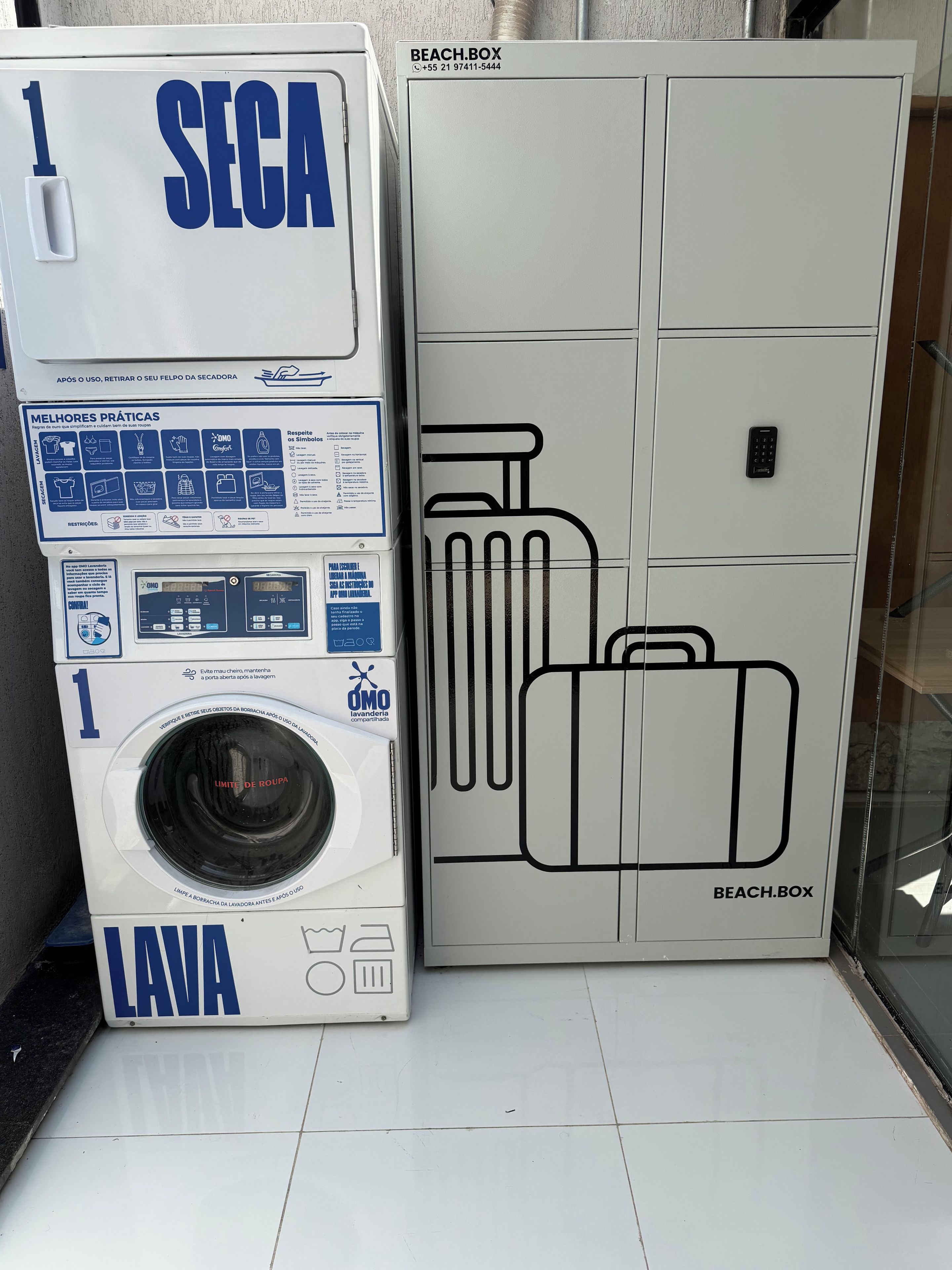 Un lavadero con lavadora y un mueble grande con diseño de maleta.