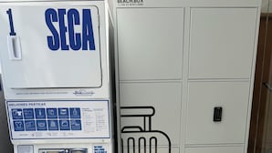 Un lavadero con lavadora y un mueble grande con diseño de maleta.