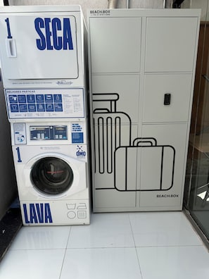 Un lavadero con lavadora y un mueble grande con diseño de maleta.