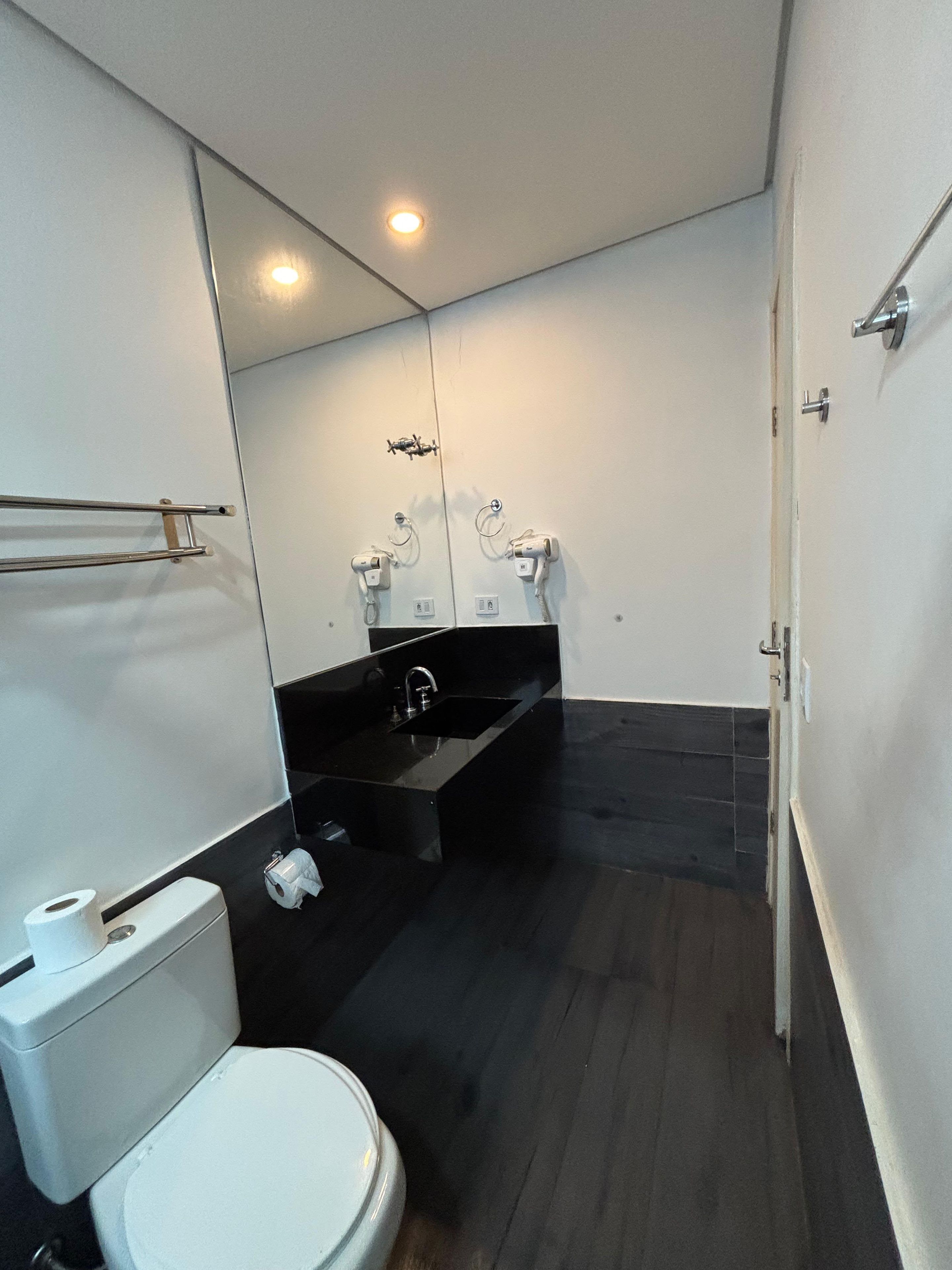 A modern bathroom with a toilet, sink, and mirror.