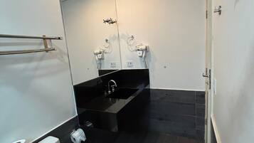 Ein modernes Badezimmer mit Toilette, Waschbecken und Spiegel.