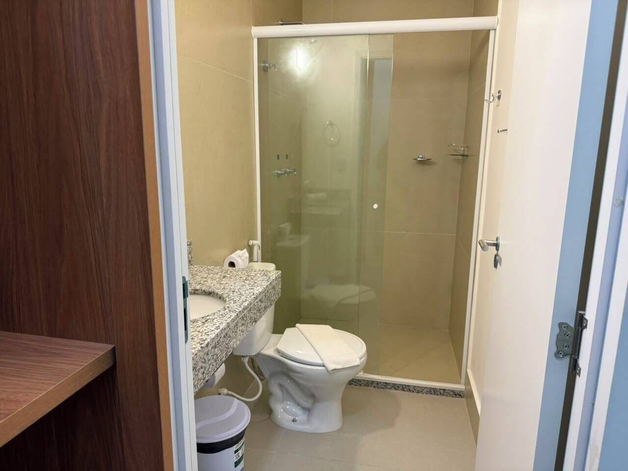 Une salle de bain avec une douche, des toilettes et un lavabo.