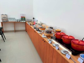 Disposição de buffet com diversos alimentos e utensílios de servir.