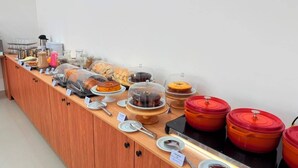 A buffet setup with various food items and containers.