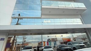 A multi-story building with a glass facade and a covered entrance.