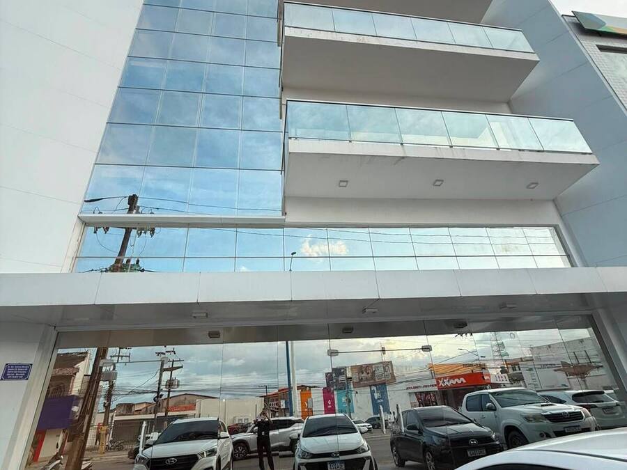 A multi-story building with a glass facade and a covered entrance.