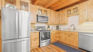 A kitchen with wooden cabinets, stainless steel appliances, and a built-in oven. - Cozy 2 Bedroom Condo in Silverthorne, CO! (Silverthorne)