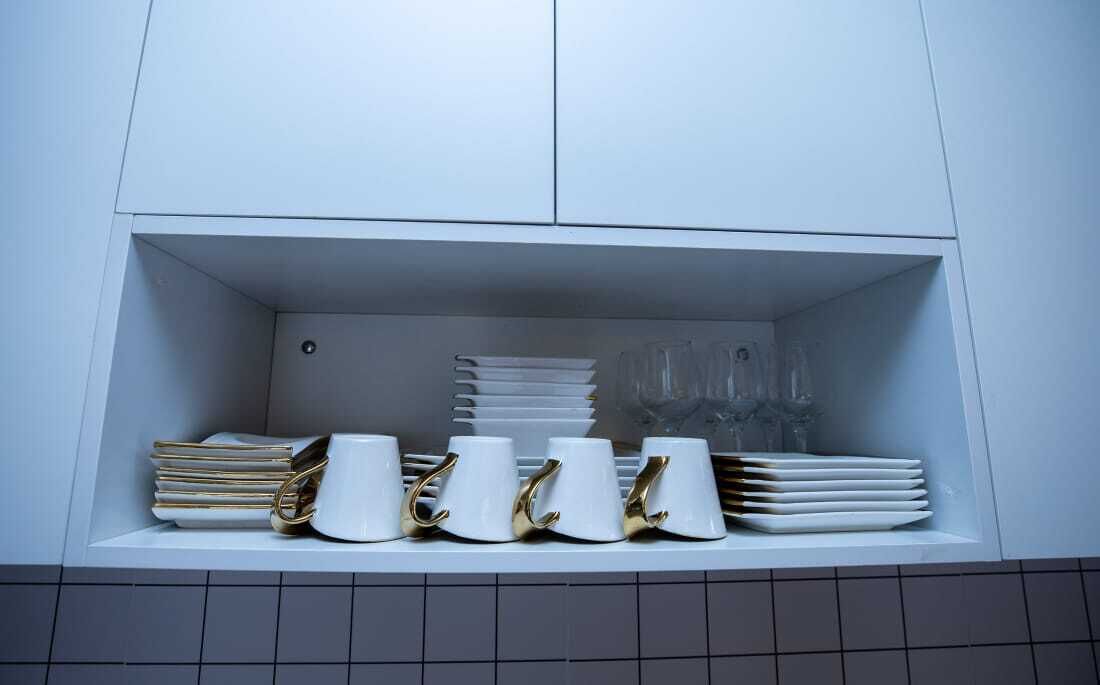 Un meuble de cuisine avec un intérieur blanc et un pare-feu en carreaux.